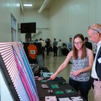 An engineering student explains her LED signage project to a guest at the Engineering Design Project Preview